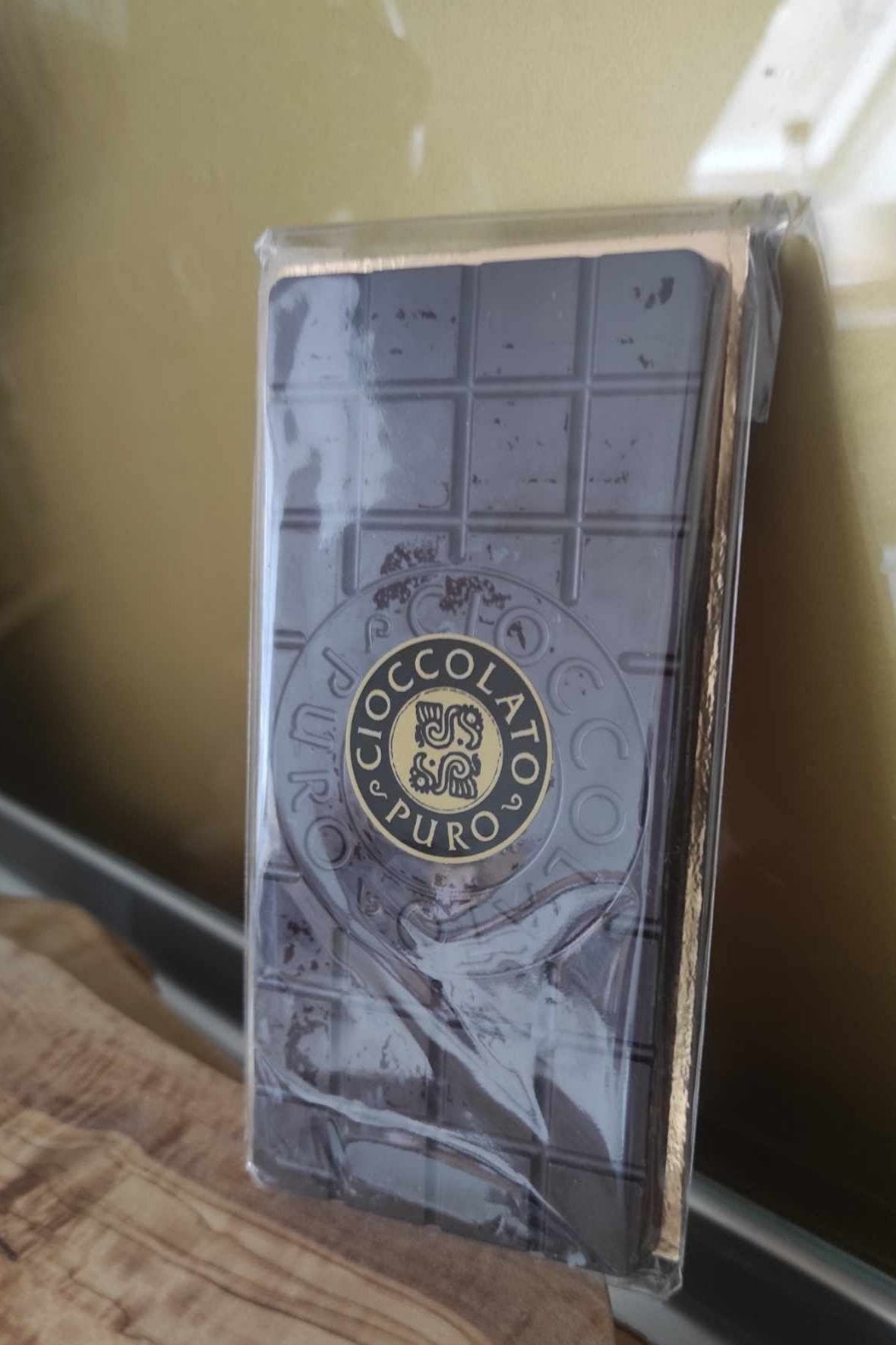 A packaged 100% Criollo Edel-Kakaotafel chocolate bar, 100g, with an elegant embossed design, showcases rich, premium cocoa.