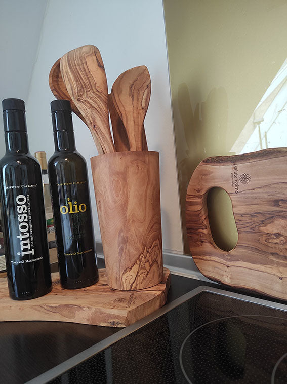 Set aus Holz-Küchenutensilien mit Olivenölflaschen auf Holzbrett, daneben ein Schneidebrett, alles aus hochwertigem Holz gefertigt.