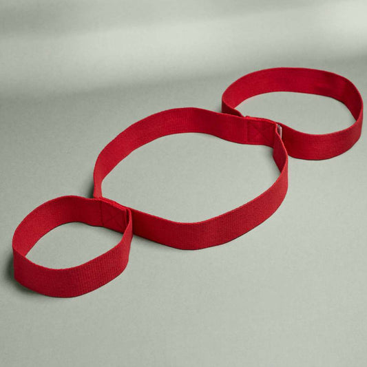 Übungsband mit Schlaufen, rotes Material, hellgrauer Hintergrund, drei verbundene Schlaufen, optimal für Fitnessübungen.