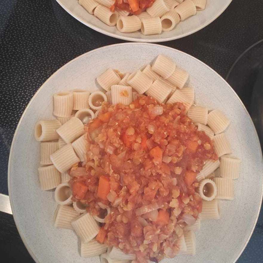 Zwei Teller Rigatoni-Pasta mit herzhaftem Tomaten-Karotten-Zwiebel-Sauce, Highlight der italienischen Kochbox-Erfahrung.