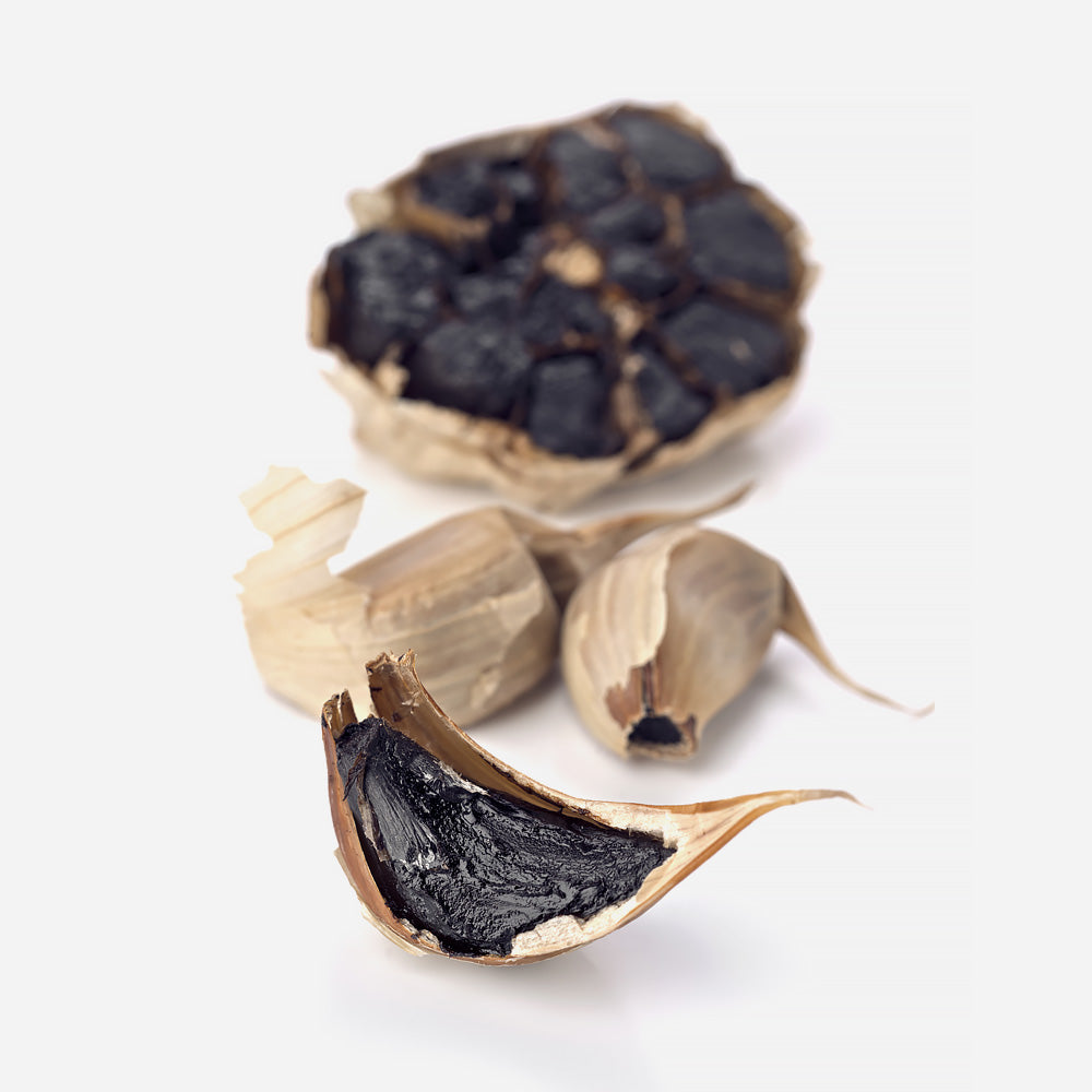 Ein schwarzer Knoblauch mit freigelegten Zehen, dunkel und glänzend, ideal für die Verwendung in Meersalzprodukten.