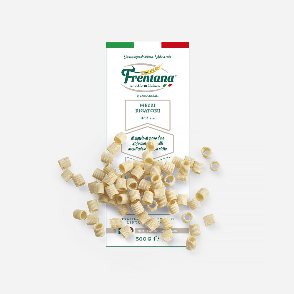 Packung Mezzi Rigatoni aus alten Getreidesorten, Marke Frentana, ausgestellt mit verstreuten ungekochten Nudelstücken.