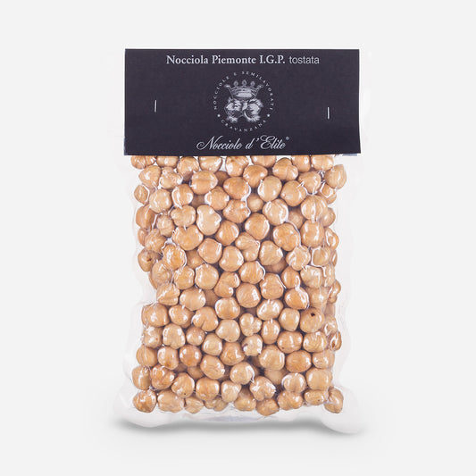 Elegante Geschenkverpackung mit gerösteten Nocciola Piemonte I.G.P. Haselnüssen, schwarzes Etikett mit stilvollem Logo und Produktnamen.
